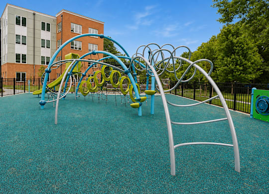 A playground with a blue and green slide and a yellow and blue climbing frame.