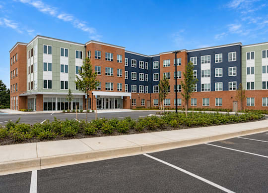 A large multi-story building with a parking lot in front.