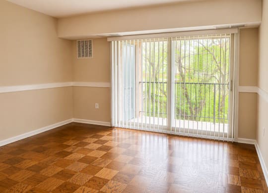 A room with a sliding glass door leading to a backyard.