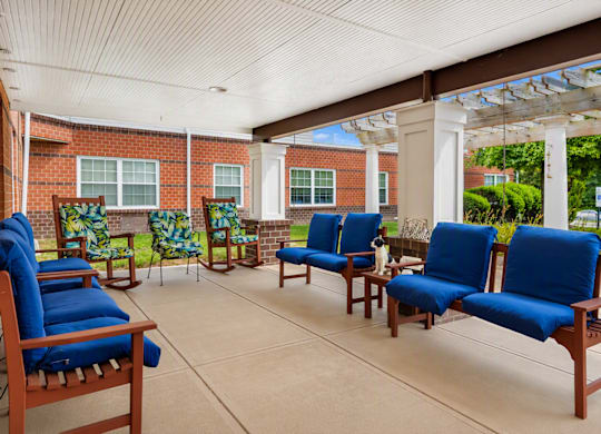 A patio with blue cushioned chairs and a white ceiling.