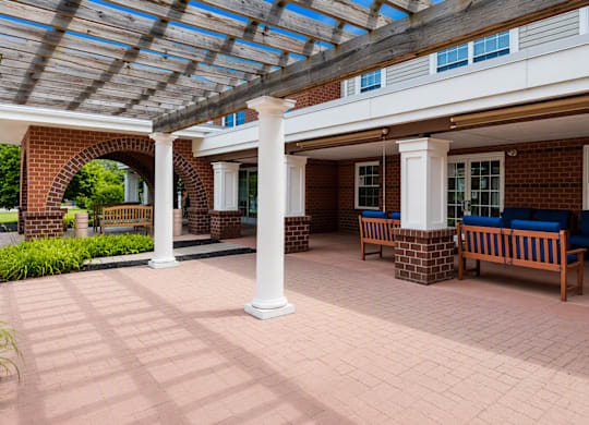 A covered walkway with benches and pillars.