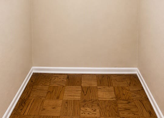 A room with two white shelves and a wooden floor.