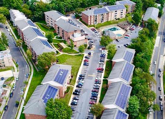 A bird's eye view of a residential area with solar panels on the roofs.