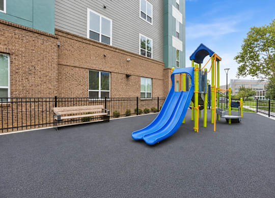 A playground with a blue slide and a yellow structure.