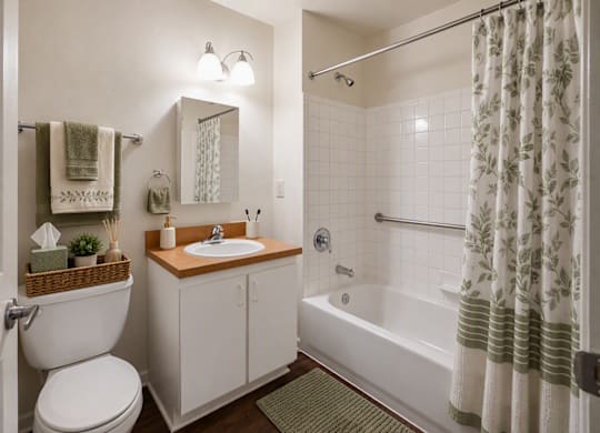 A white bathroom with a toilet, sink, and bathtub.