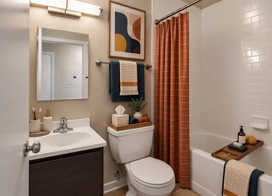 A bathroom with a toilet, sink, and shower.