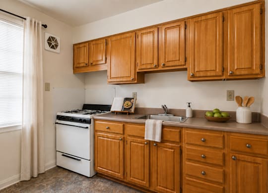 A kitchen with wooden cabinets and a white stove.