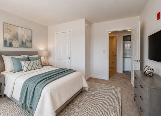 A bedroom with a bed, nightstand, and a painting on the wall.