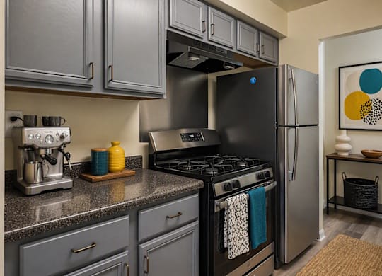 A modern kitchen with a black fridge and stove.