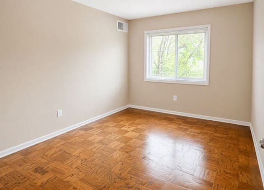 A room with a wooden floor and a window.