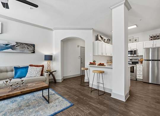 A modern kitchen with a dining area and a living room.