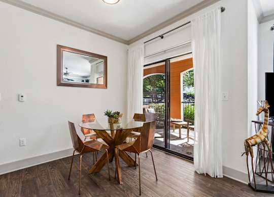 A dining room with a glass table and chairs.
