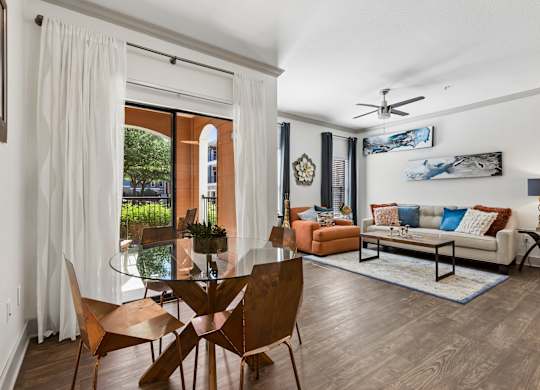 A modern living room with a glass table and chairs.