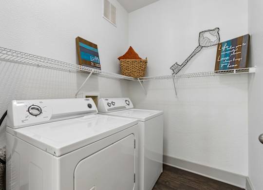 A white washing machine and dryer in a small laundry room.