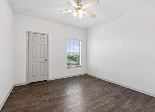 A room with a ceiling fan and a door.