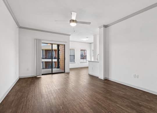 A room with wooden floors and a ceiling fan.