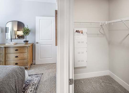 A white bedroom with a grey carpet and a white wardrobe at Folksong Apartments, Flowery Branch, GA