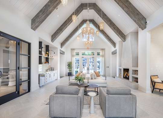 A large, open-concept living room with a high ceiling and a fireplace at Folksong Apartments, Flowery Branch, Georgia