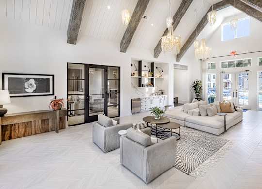 A spacious living room with a high ceiling and a large window at Folksong Apartments, Flowery Branch