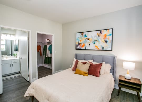Octave Apartments a bedroom with a bed and a nightstand with a lamp at Octave Apartments, Las Vegas, 89123