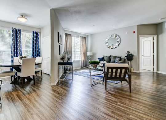 Large, open-concept living area with plank flooring, large windows, and a separate dining area at Tuscany Bay Apartments, Tampa, FL, 33626