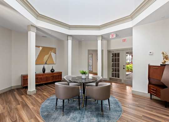 A dining room with a round table and chairs.