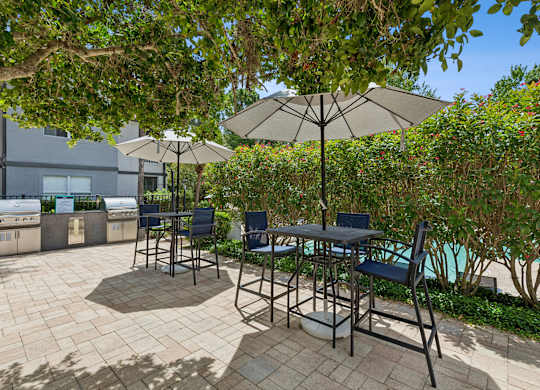 A patio with a table and chairs under umbrellas.
