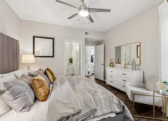 A bedroom with a bed, dresser, and mirror.