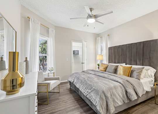 A bedroom with a large bed and a ceiling fan.