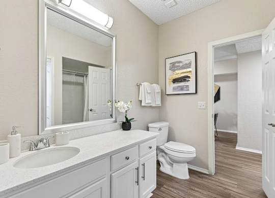 A bathroom with a white sink and toilet.