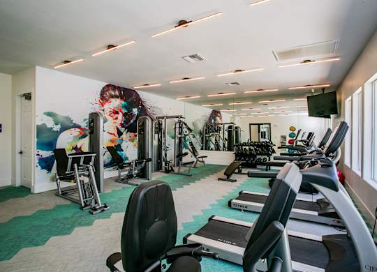 A gym with treadmills, weights, and exercise equipment. at Octave Apartments, Las Vegas, NV, 89123