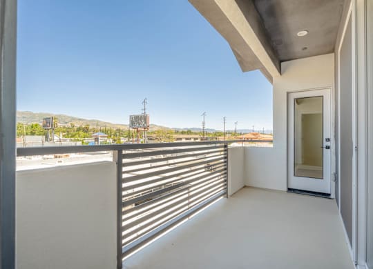 A balcony with a metal railing and a door leading to the outside.