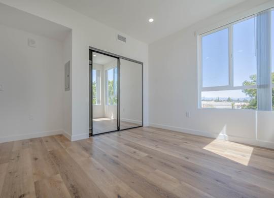 A room with a sliding glass door leading to a balcony.