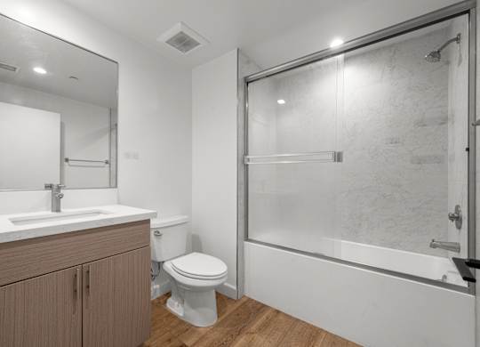 A bathroom with a toilet, sink, and shower.