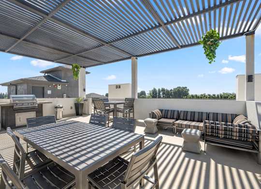 A patio with a table and chairs under a roof.