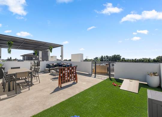 A patio with a table and chairs under a pergola.