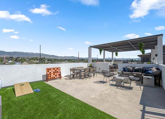A patio with a white wall and a white pergola.