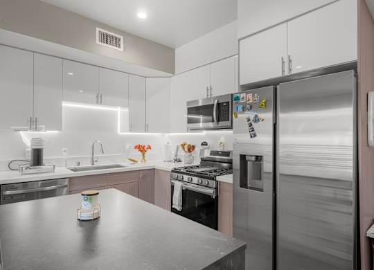 A modern kitchen with stainless steel appliances and a central island.
