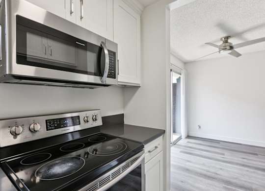 A modern kitchen with a stainless steel stove and microwave.