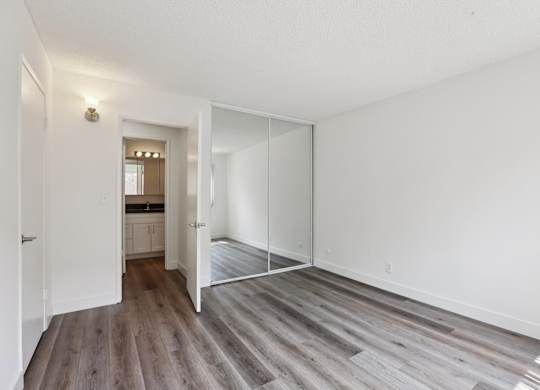 A room with a white wall and a wooden floor.
