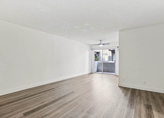A room with wooden flooring and a ceiling fan.