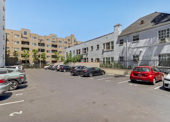 A parking lot with cars and buildings in the background.