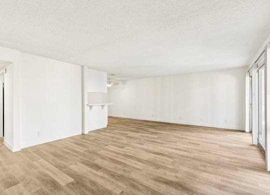 A room with wooden flooring and white walls.