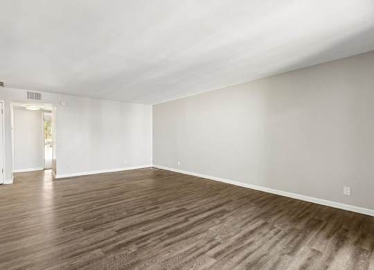 A room with wooden flooring and white walls.