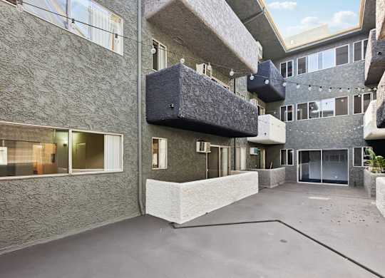 A courtyard surrounded by buildings with a concrete floor.
