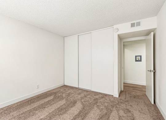 A room with a carpeted floor and a white door.