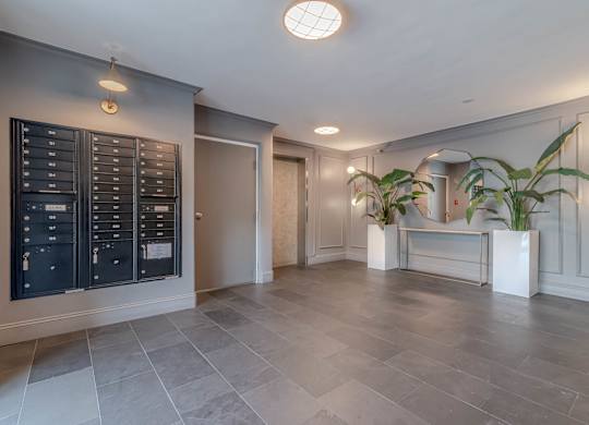 A spacious room with a grey floor and a black cabinet on the wall.