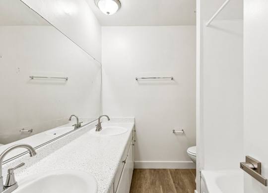 A white bathroom with a sink and toilet.