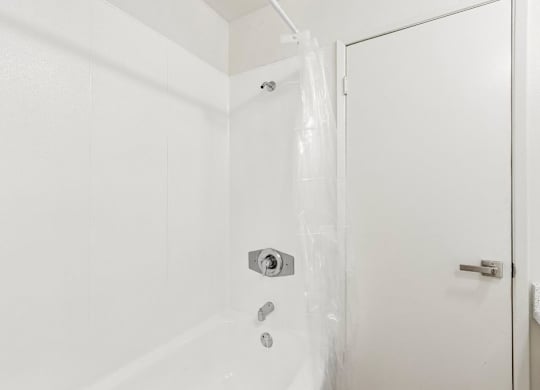 A white door with a silver handle and a silver lock.