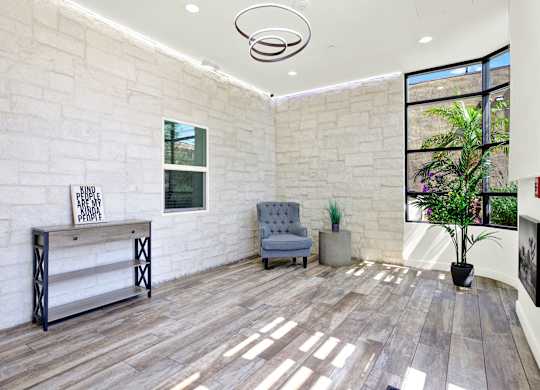 A room with a white brick wall and a wooden floor.